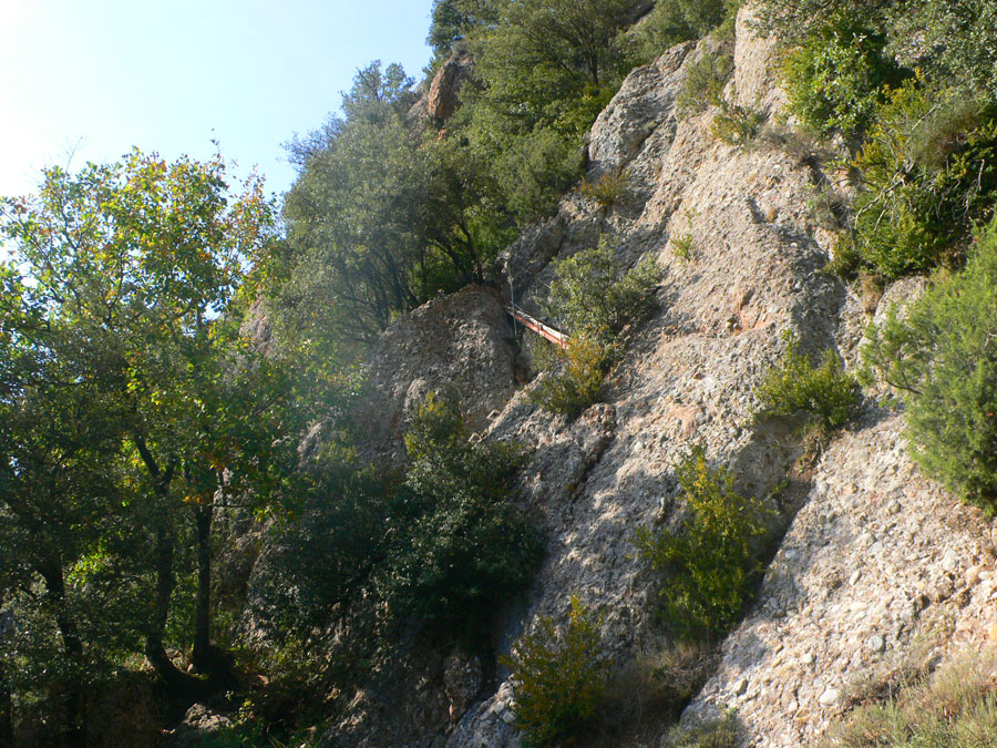 Vista del paso equipado -escalones de vía ferrata blancos y una corta pasarela 