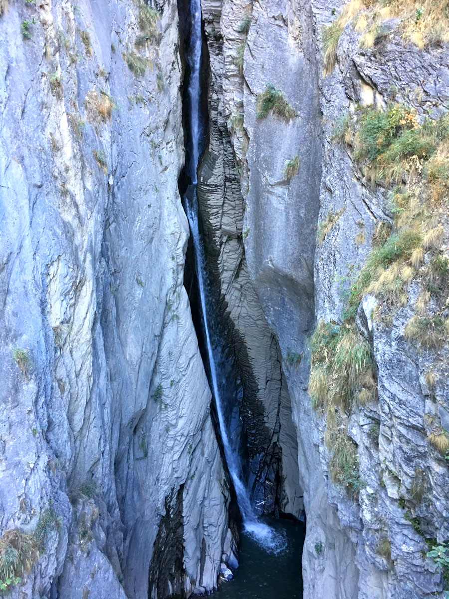 Vistas desde el puente tibetano a una esbelta caída de agua 