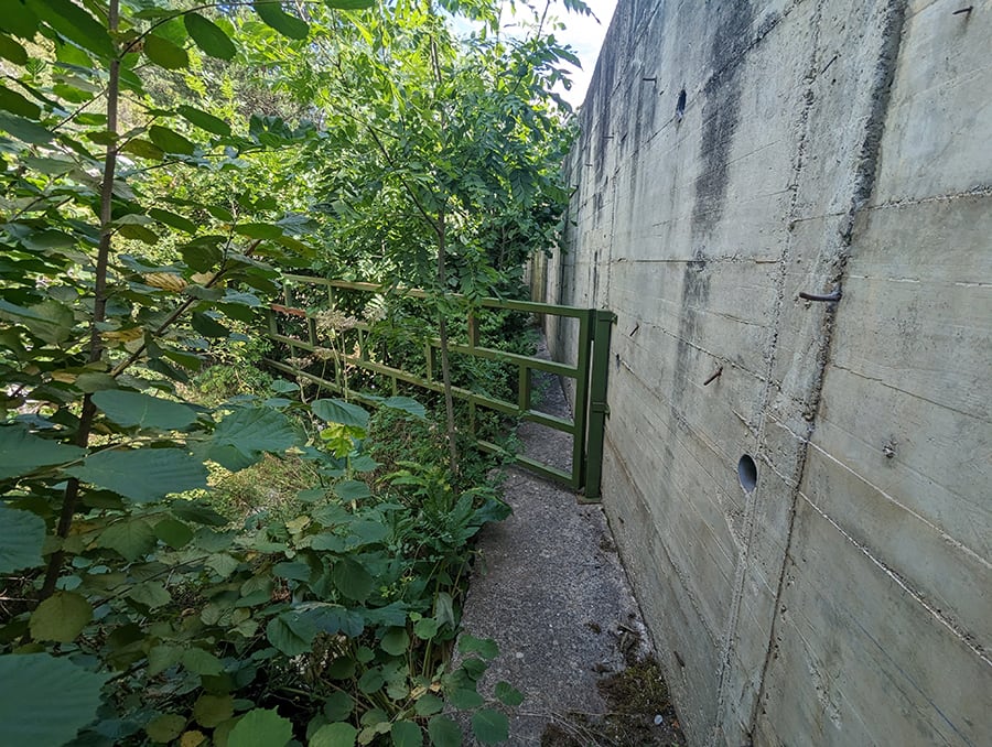  Vista atrás a la puerta metálica que hemos superado pegados a la pared del torrente 