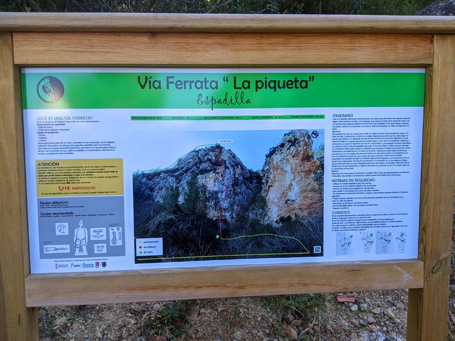 Plafón informativo de la vía ferrata a la entrada del camino de aproximación junto al estacionamiento y la pista de fútbol 
