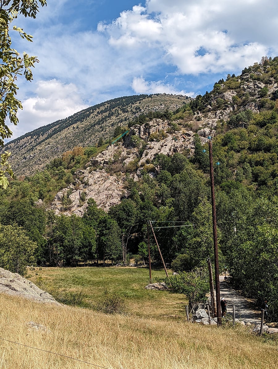 Vista del camino de aproximación desde el estacionamiento. Se ven algunas instalaciones del parque de aventura al fondo 