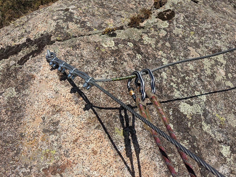 Detalle de la equipación y el sistema de seguridad tipo vía ferrata con dos mosquetones clásicos 