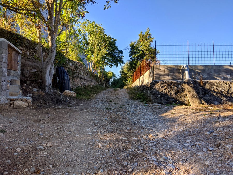 Rampa de subida en el camino de  aproximación junto a una balsa de agua y campos 