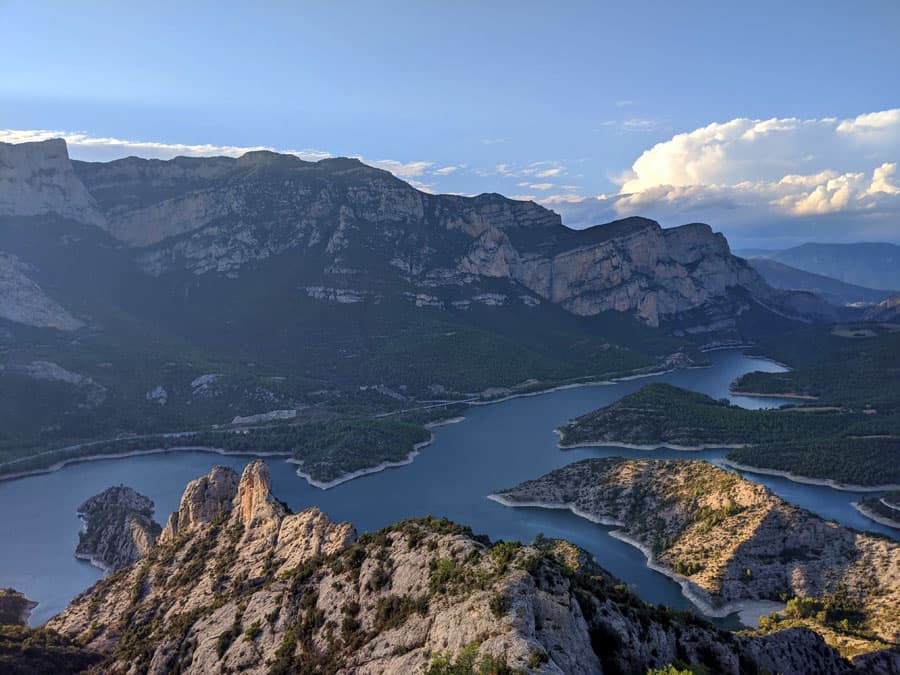 Desde la cima vistas al norte hacia el pantano de Oliana y al fondo las paredes <em>dels Espolvins</em> de la antigua vía ferrata Regina de Peramola 