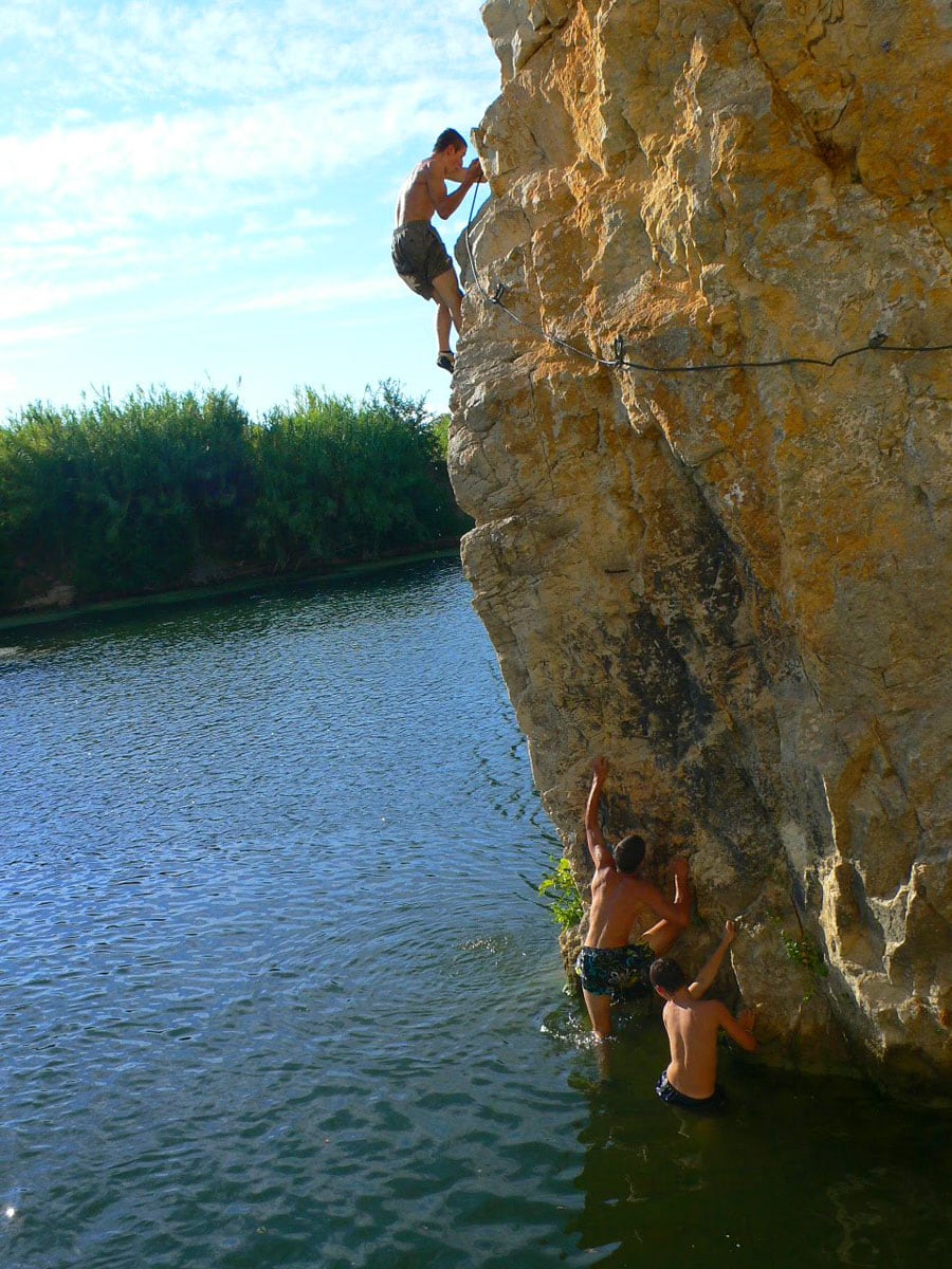 Chicos usando la ferrata para subir y tirarse al río 